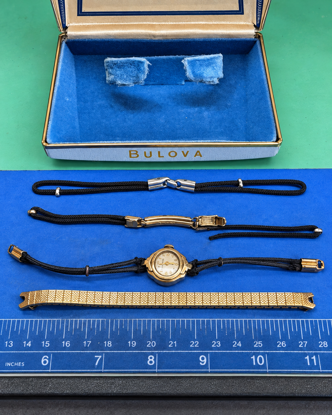 Vintage Bulova watch with cord bracelets, clasp hardware and metal bracelet laid out for comparison